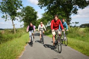 um grupo de pessoas andando de bicicleta por uma estrada em Ferienhof Westermann Waldblick em Lähden