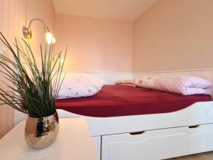 a bed in a room with a potted plant at RosenGärtchen in Vadersdorf