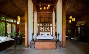 ein Schlafzimmer mit einem Bett in einem großen Zimmer in der Unterkunft Kalapa Boutique Resort & Yoga in Canggu