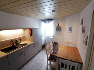 uma cozinha com uma mesa de madeira e uma sala de jantar em Ferienhaus Ostwald em Deutscheinsiedel