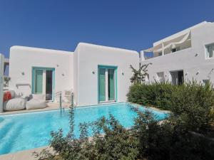 a villa with a swimming pool next to a building at Majo Suites Hotel in Agia Anna Naxos