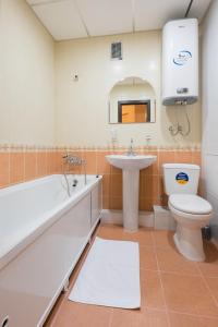 a bathroom with a sink and a tub and a toilet at Apart Petrovskie on Sovetskaya 69 in Tomsk