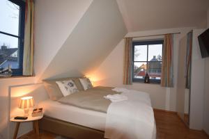 a bedroom with a bed and two windows at Ostseebrise FH 1 in Zingst