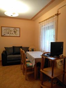 a living room with a table and a couch at Zsuzsi Apartman in Zalakaros