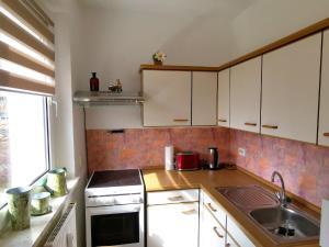 a small kitchen with white cabinets and a sink at Ferienwohnung Kaltschmidt in Radebeul