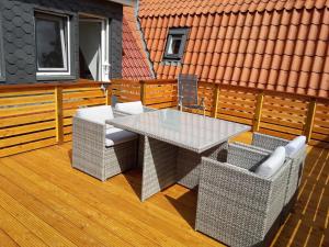 a patio with a glass table and chairs on a deck at Ferienwohnung Max 2 in Grube