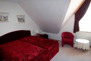 a bedroom with a red bed and a red chair at Herrmann - Ferienwohnung 3 in Dahme