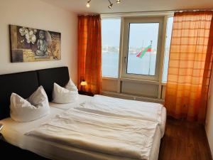- une chambre avec un lit et une grande fenêtre dans l'établissement Apartment 45, à Wilhelmshaven