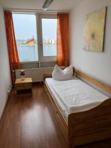 - une petite chambre avec un lit et 2 fenêtres dans l'établissement Apartment 45, à Wilhelmshaven