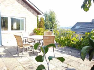 a patio with a table and chairs in a yard at Burgblick-Fewo Töpfer in Annweiler am Trifels