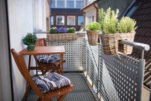 a balcony with a table and chairs and potted plants at "Sprotte" in Eckernförde