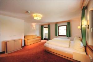 - une chambre avec un lit et un canapé dans l'établissement Appartementhaus zum Zegger, à Neustift im Stubaital