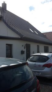 two cars parked in front of a house at Lissis Feriendomizil in Ostseebad Karlshagen