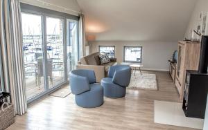 a living room with a couch and two chairs and a television at Ostsee - Appartement "Pier 77" im Strand Resort in Heiligenhafen