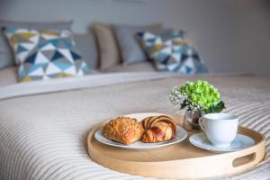 a tray with bread and a cup of coffee on a bed at Ostsee - Appartement "Pier 77" im Strand Resort in Heiligenhafen
