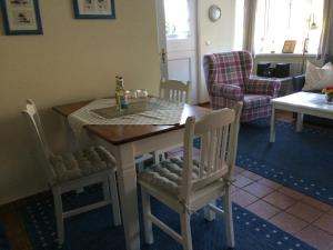 a kitchen with a table and chairs with a bottle on it at Pastoratshof Whg 4 in Wrixum