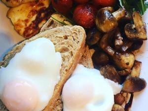 een bord met een ei, brood en champignons bij Frasers Battlesbridge in Battlesbridge