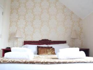 a bedroom with a bed with two pillows at Frasers Battlesbridge in Battlesbridge +4 photos