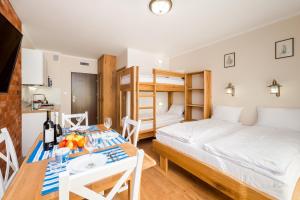 sypialnia z łóżkiem, stołem i łóżkiem oraz kuchnia w obiekcie Villa Kliwer 50 metrów od morza w Rowach
