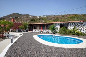 a swimming pool in front of a house at CASA RURAL LOS DRAGUITOS 2 in Santa Cruz de la Palma