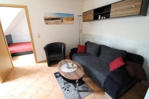 uma sala de estar com um sofá e uma mesa em Strandperle App 10 em Dierhagen
