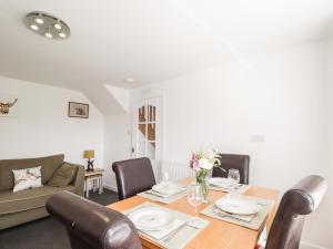 a dining room with a table and chairs and a couch at Clyne Cottage in Elgin