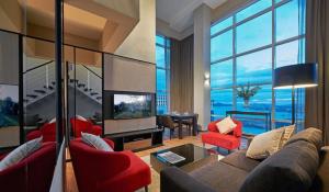 a living room with a couch and red chairs at Maritime Luxury Suites in George Town