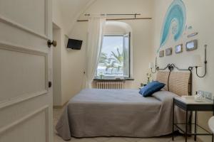 a bedroom with a large bed and a window at Hotel Vita Serena in Arma di Taggia