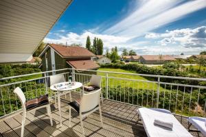 eine Terrasse mit einem Tisch und Stühlen auf dem Balkon in der Unterkunft Typ F "Holger Ehlers" -Kapitänshaus- in Pelzerhaken