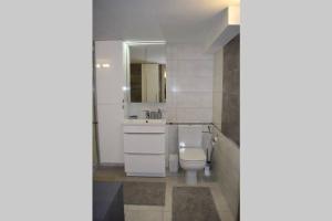 bagno con servizi igienici, lavandino e specchio di Przytulny apartamentt a Jabłonka