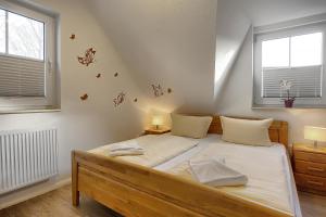ツィングストにあるAm Deich 37 Sandkornのベッドルーム1室(ベッド1台、窓2つ付)