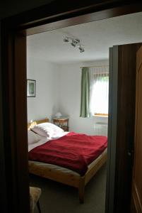 プレローにある"Am Prerow Strom"のベッドルーム1室(赤いシーツ付きのベッド1台、窓付)