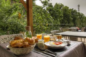 a table with a basket of bread and glasses of orange juice at Chambre d'hôtes couvent d'Alando in Alando