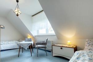 a bedroom with two beds and a table and a chair at Bossow, Regina in Zingst