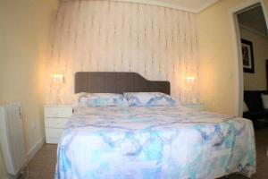 a bedroom with a bed with a blue and white comforter at Apartamento cercano a Madrid Rio céntrico Nuevo in Madrid