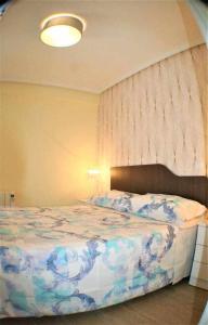 a bedroom with a bed with a blue and white comforter at Apartamento cercano a Madrid Rio céntrico Nuevo in Madrid