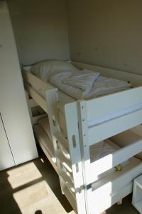 a white bunk bed in a small room at Fehmarn-OstseeferienStrandresidenz Vogelflug 1438 in Fehmarnsund