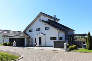 a large white house with a driveway at Ferienhaus ALB-QUELLE in Gomadingen