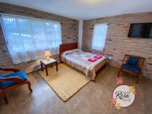 a bedroom with a bed and a brick wall at Santa Rosa de Lima Hostal Zuleta in Hacienda Zuleta