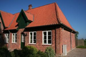 a red brick house with an orange roof at Bellevue rechts in Schashagen