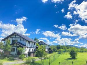 uma casa num campo com um céu azul e nuvens em Okayama Hiruzen Villas Peter Pan em Makago