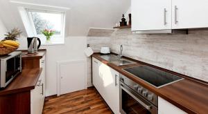 a kitchen with white cabinets and a sink at Storchennest - 58270 in Süsel