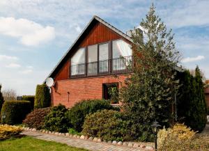 a brick house with a balcony on top of it at Storchennest - 58270 in Süsel
