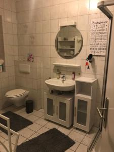 a bathroom with a sink and a toilet and a mirror at Schöne Auszeit RE14 in Sögel