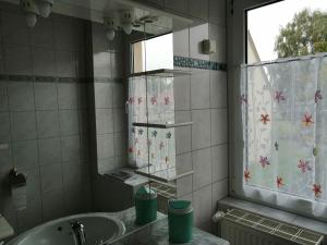 een badkamer met een wastafel en een spiegel bij Fewo 2 in Sassnitz