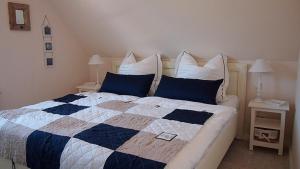 a bedroom with a bed with a blue and white quilt at Jolle in Zingst