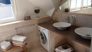 a bathroom with a washing machine and a sink at Jolle in Zingst