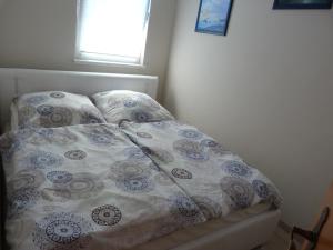a bed with a comforter and pillows in a bedroom at Bungalow Mandy in Zinnowitz