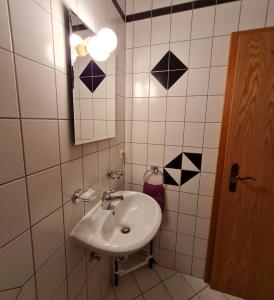 a bathroom with a sink and a mirror at Pension & Ferienhof Glüß in Lünzen +15 photos