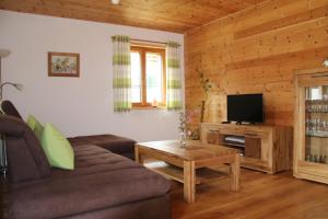 uma sala de estar com um sofá e uma televisão em Naturhaus Altmuehltal em Titting